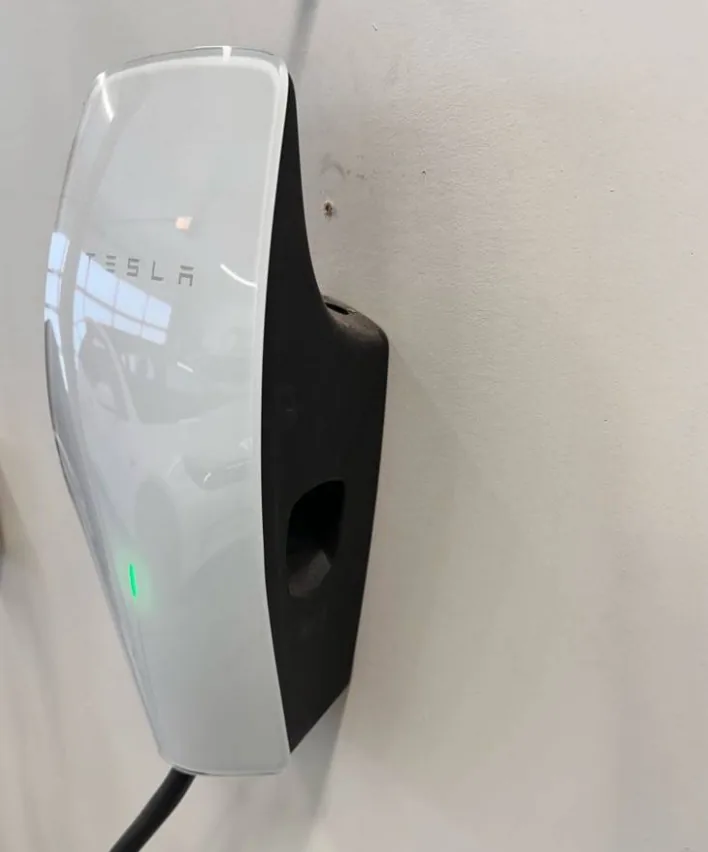 Wall-mounted Tesla EV charging station installed at a home