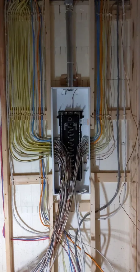 Electrical panel with bundled cables running through an open wall frame